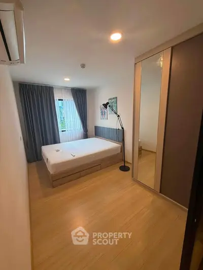 Spacious bedroom with modern decor and large window for natural light
