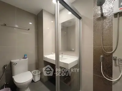 Modern bathroom with glass shower and sleek fixtures in contemporary apartment.