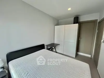 Modern bedroom with minimalist design featuring a comfortable bed and sleek wardrobe.