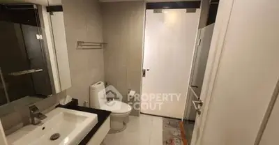 Modern bathroom with sleek fixtures and neutral tones, featuring a spacious layout and contemporary design.