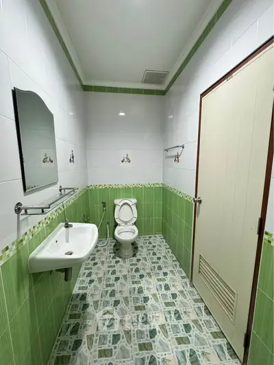 Spacious bathroom with modern fixtures and green tile accents