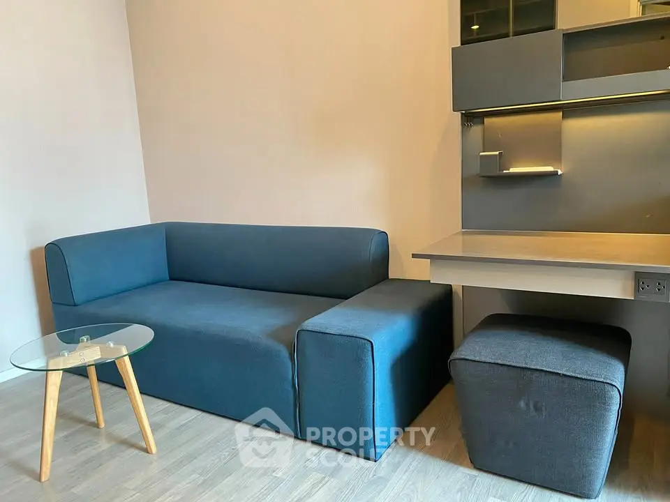 Modern living room with stylish blue sofa and sleek glass coffee table