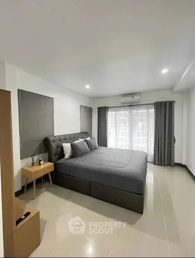 Spacious modern bedroom with elegant decor and ample natural light