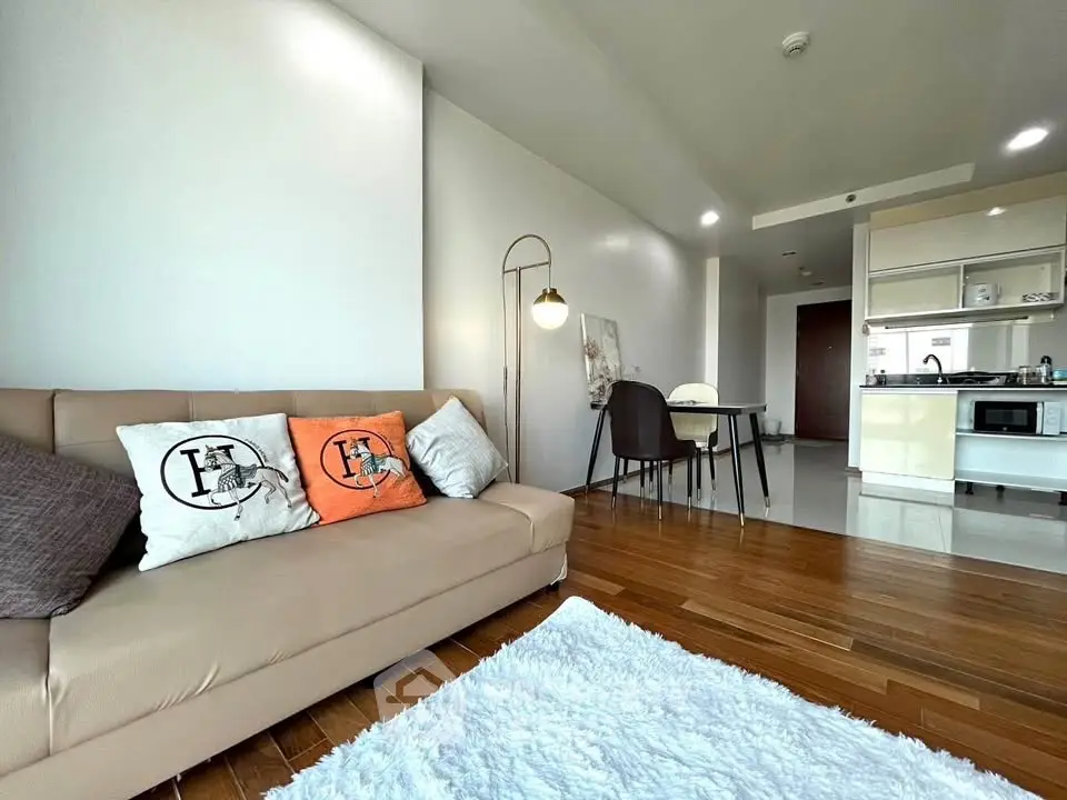 Modern living room with cozy sofa and stylish dining area in open layout apartment.