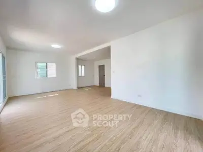 Spacious empty living room with wooden flooring and natural light