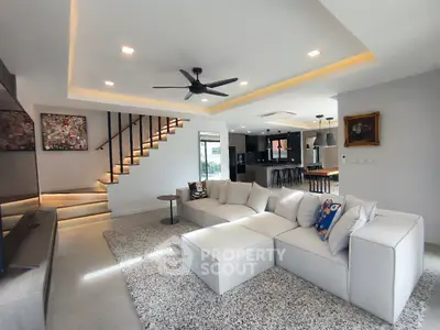 Spacious modern living room with stylish open kitchen and elegant staircase