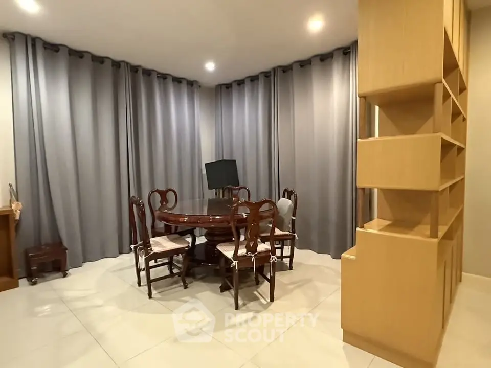 Elegant dining area with round table and modern shelving unit