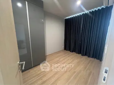 Spacious empty room with wooden flooring and large wardrobe, ideal for customization.