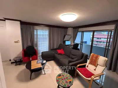 Spacious living room with modern decor and balcony view in urban apartment.