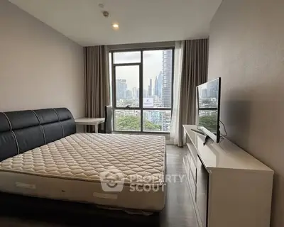 Spacious bedroom with city view, featuring a large bed and modern furnishings.