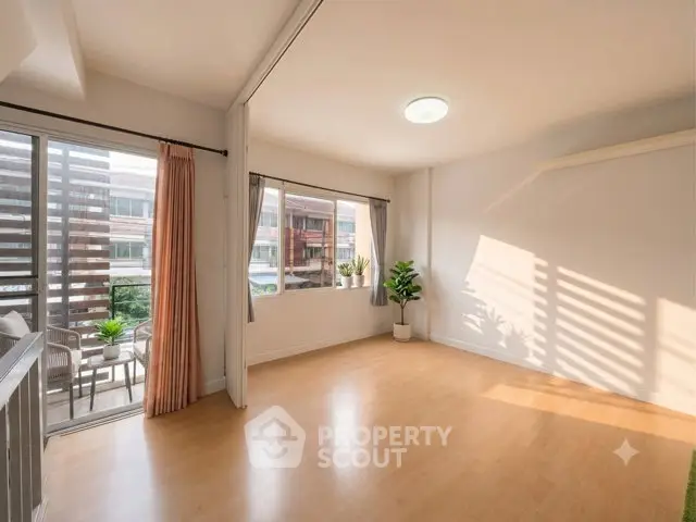 Spacious sunlit living room with balcony access and modern decor.