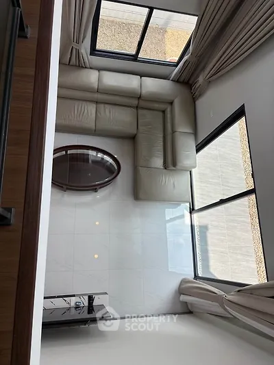 Modern living room with large windows and L-shaped sofa