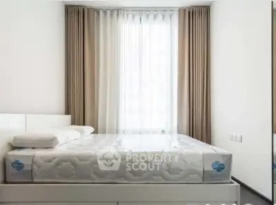 Modern bedroom with natural light and elegant curtains, featuring a comfortable bed and minimalist design.