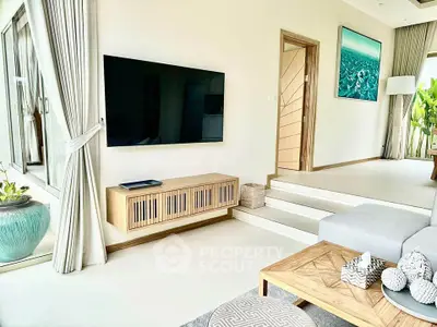 Modern living room with sleek TV, stylish decor, and natural light.