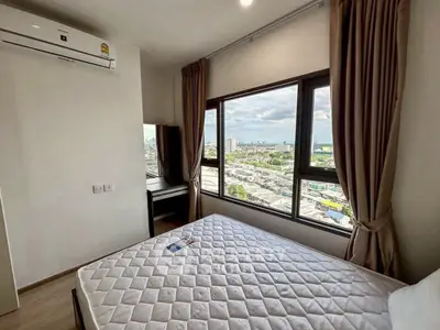 Modern bedroom with large window offering stunning city view