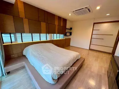Spacious modern bedroom with unique wood paneling and minimalist design.