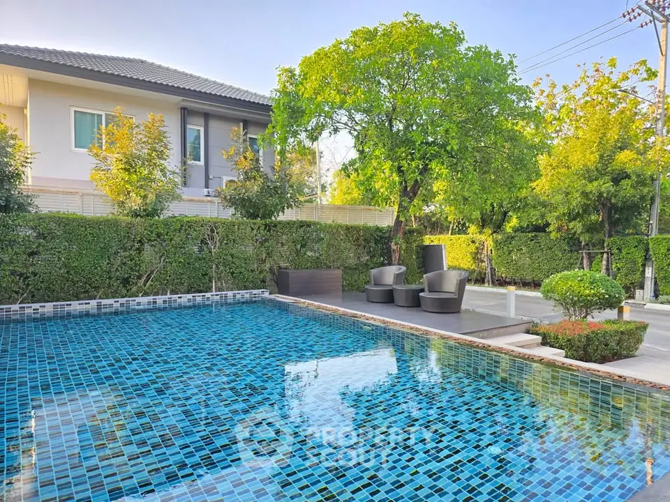 Luxurious outdoor pool area with modern seating and lush greenery