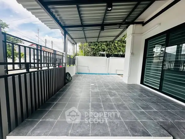 Spacious covered patio with modern tiles and sliding glass doors in a contemporary home.
