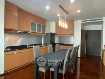 Spacious modern kitchen with sleek dining area and elegant lighting fixtures.