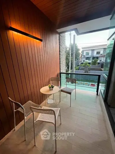 Charming balcony with modern seating and warm lighting, perfect for relaxation and enjoying the view.
