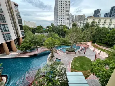 Luxurious residential complex with stunning pool and lush gardens in urban setting.