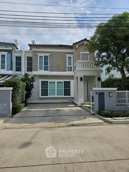 Charming two-story townhouse with modern facade and driveway in a serene neighborhood.