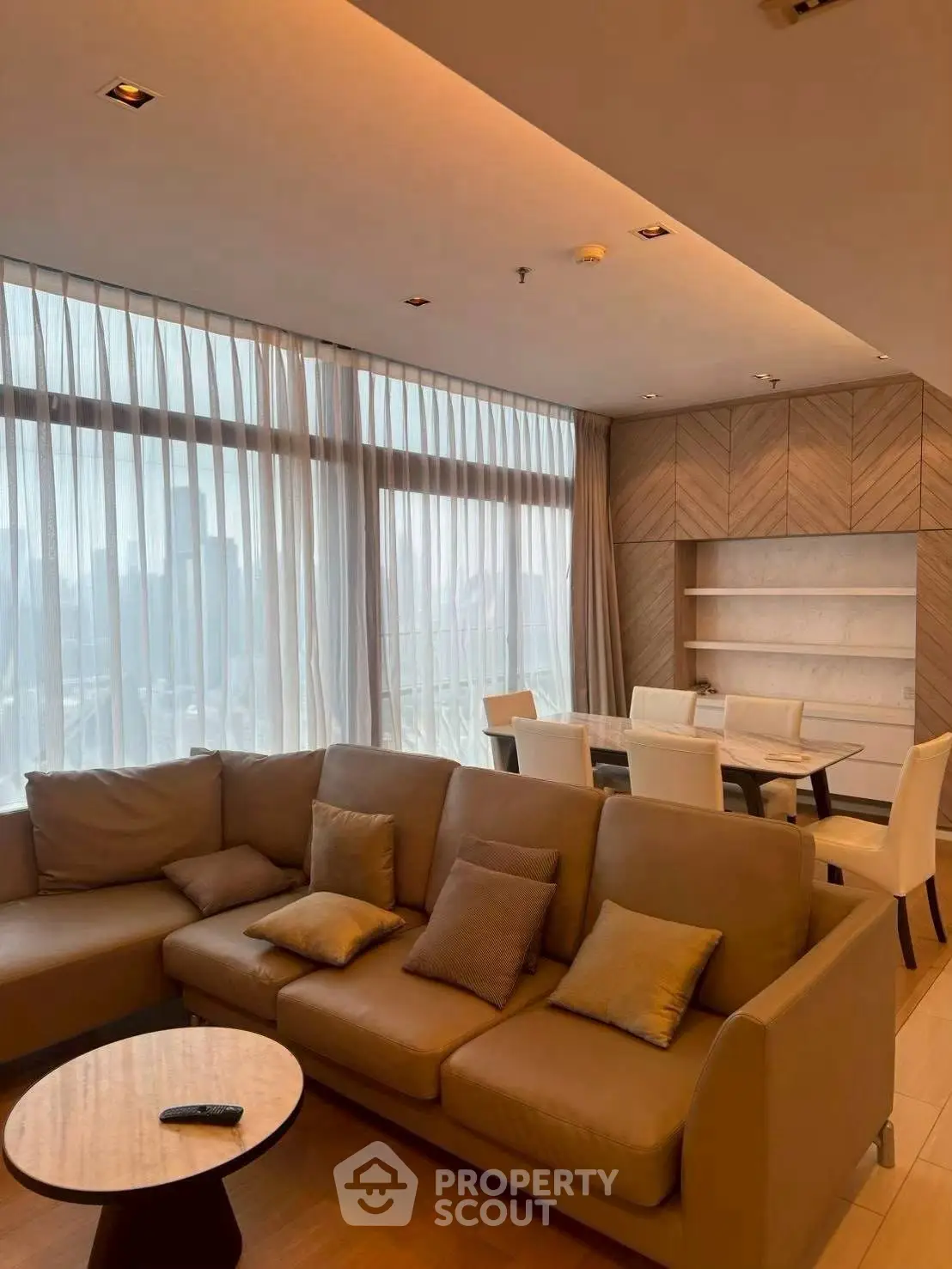 Luxurious living room with elegant decor and city view, featuring a cozy sofa and dining area.