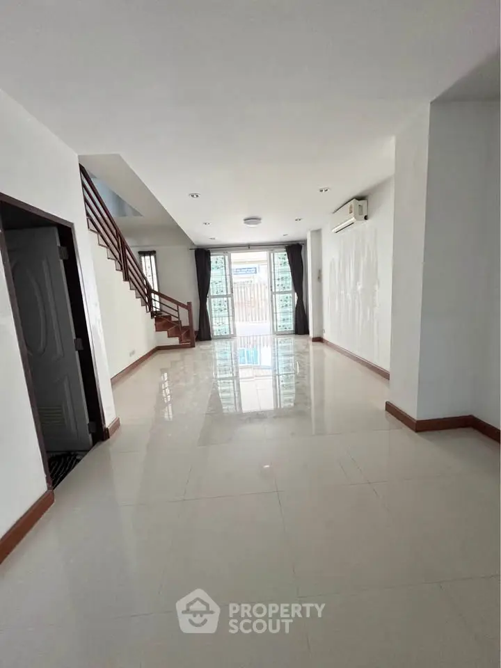 Spacious modern living room with glossy tiled floors and large windows