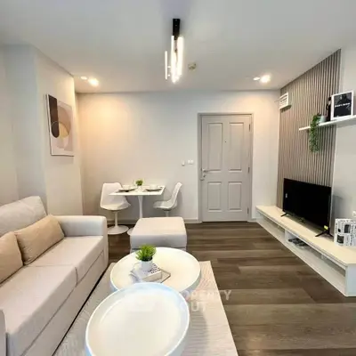Modern living room with stylish decor and open layout, featuring cozy seating and elegant lighting.
