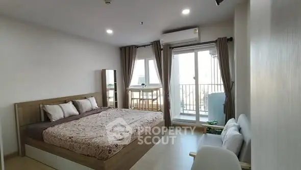 Spacious bedroom with balcony access in modern apartment