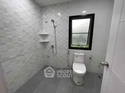 Modern bathroom with sleek tiles and a large window for natural light.