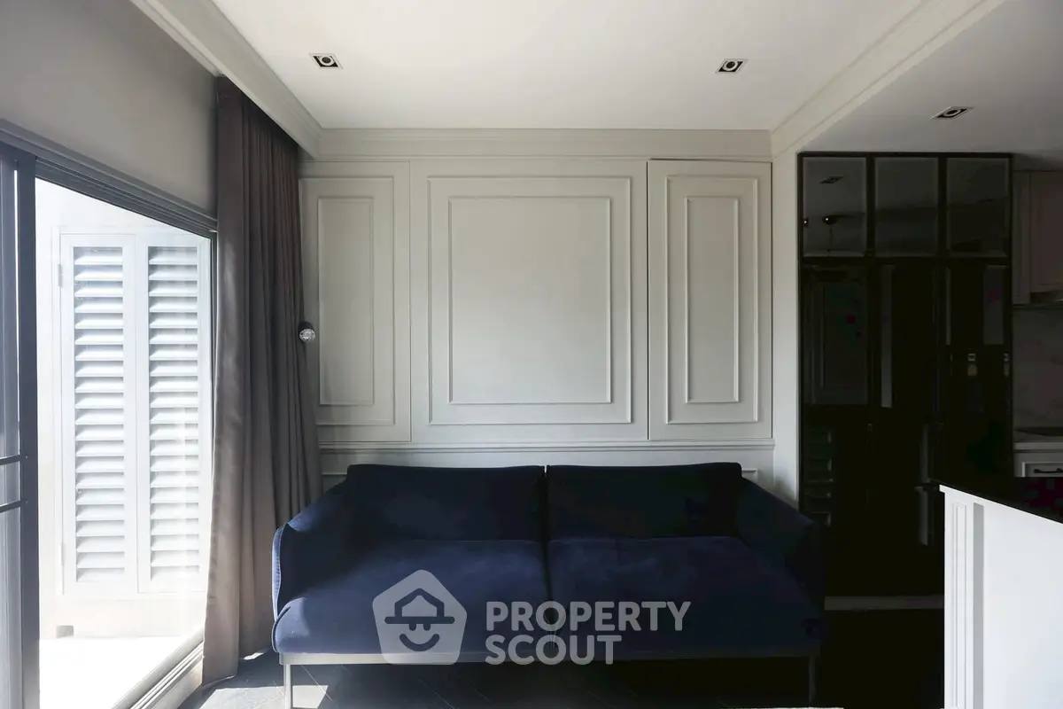 Modern living room with elegant dark sofa and stylish paneling