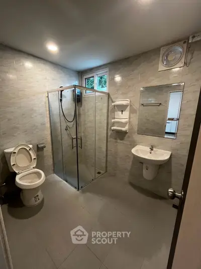 Modern bathroom with glass shower and sleek fixtures in a contemporary home.