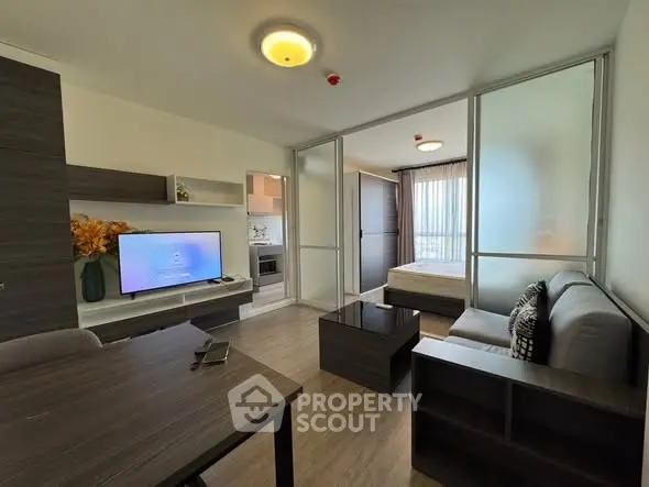 Modern living room with open layout and stylish furniture in a cozy apartment setting.