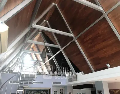 Stunning modern loft with high wooden ceilings and spiral staircase, perfect for stylish urban living.