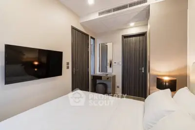 Modern bedroom with wall-mounted TV and stylish decor