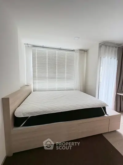 Spacious bedroom with modern design and large window blinds