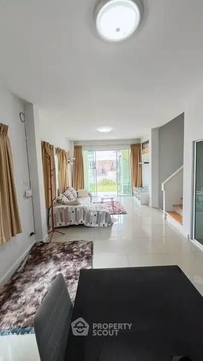 Spacious living room with modern decor and large windows offering natural light.