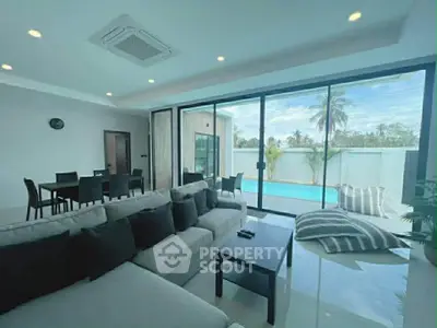 Luxurious living room with pool view and modern furnishings