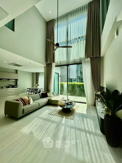 Luxurious modern living room with high ceilings and large windows offering abundant natural light.