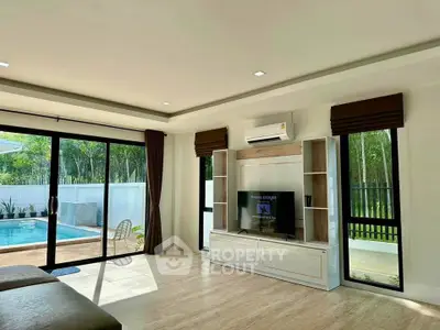 Spacious living room with pool view and modern entertainment center