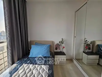 Modern bedroom with city view, featuring a single bed, mirrored wardrobe, and stylish decor.