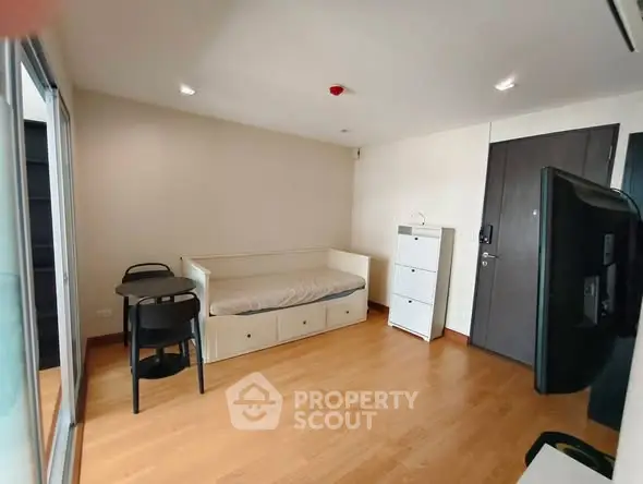Modern studio apartment with wooden flooring and minimalist furniture