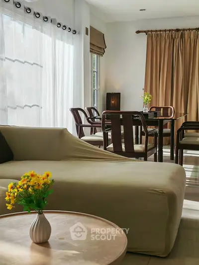 Elegant living room with natural light, stylish furniture, and cozy ambiance, perfect for relaxation and entertaining.