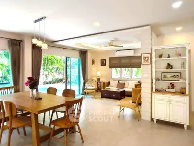 Spacious living room with pool view and elegant dining area