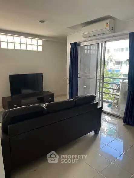 Modern living room with sleek furniture and balcony view, perfect for urban living.
