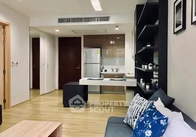 Modern open-plan living room with sleek kitchen and cozy seating area.