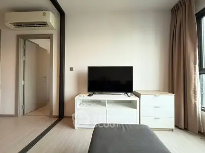 Modern living room with sleek TV setup and air conditioning in a bright apartment.