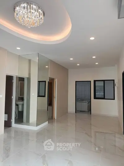 Spacious modern living room with elegant chandelier and glossy tile flooring