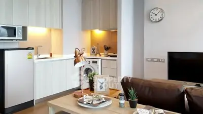 Modern living room with kitchen featuring washing machine and microwave